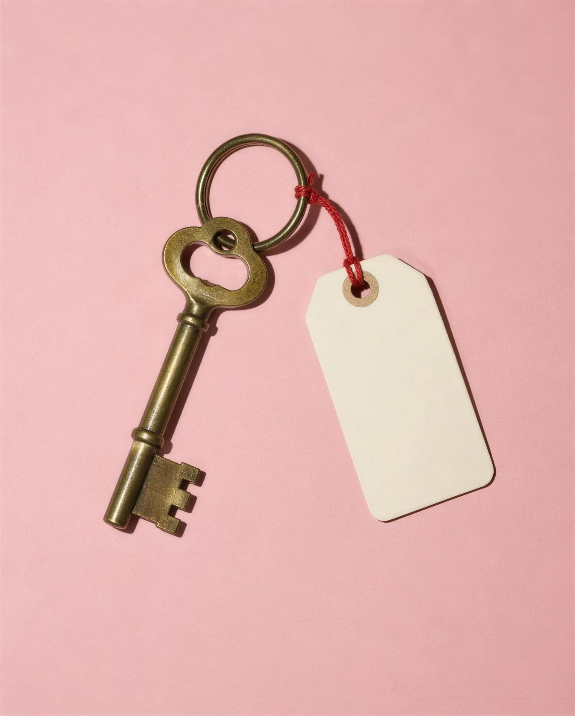 A brass venue key with a paper tag reading Juniper Hall, booked