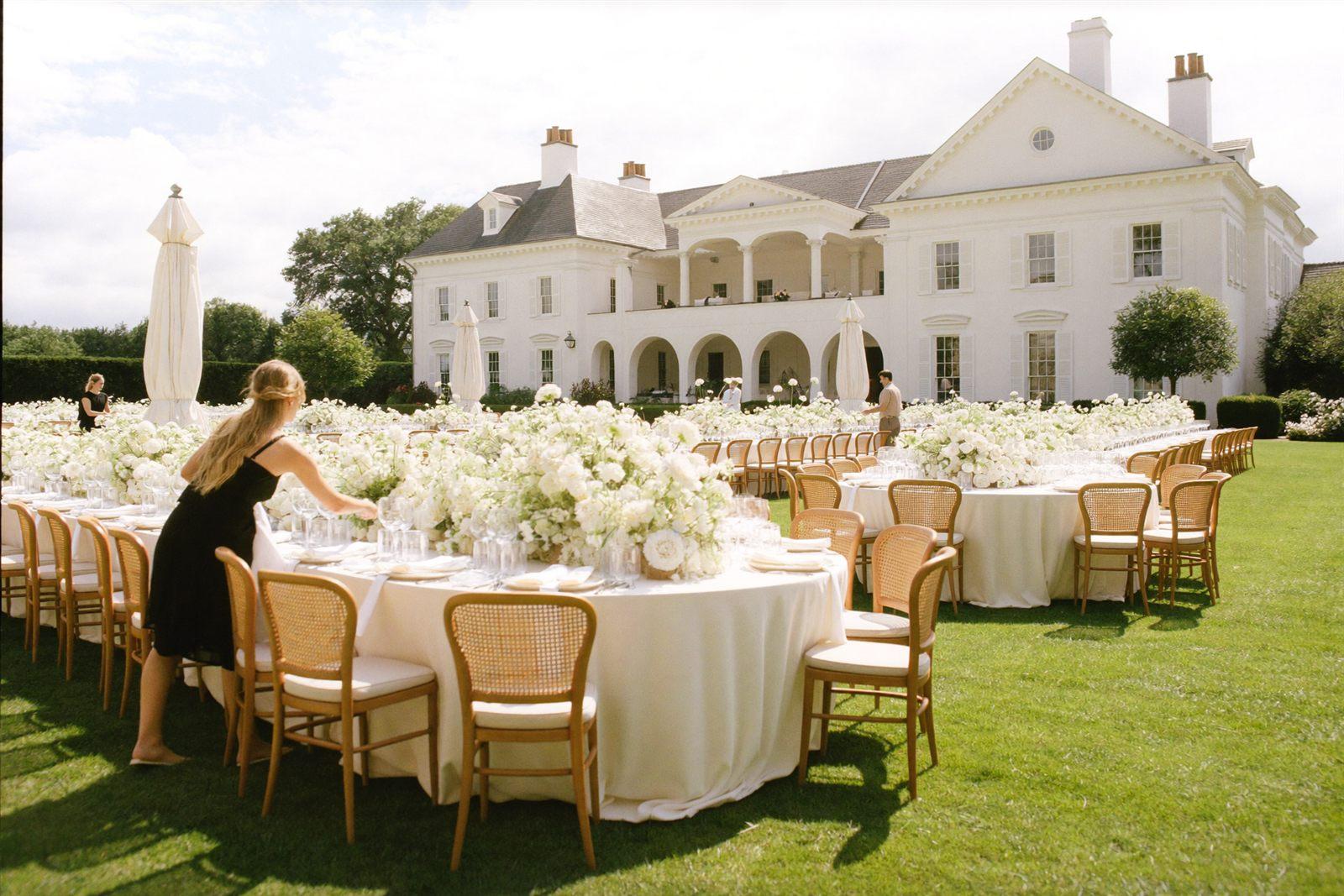 A bright white estate wedding venue with an outdoor reception