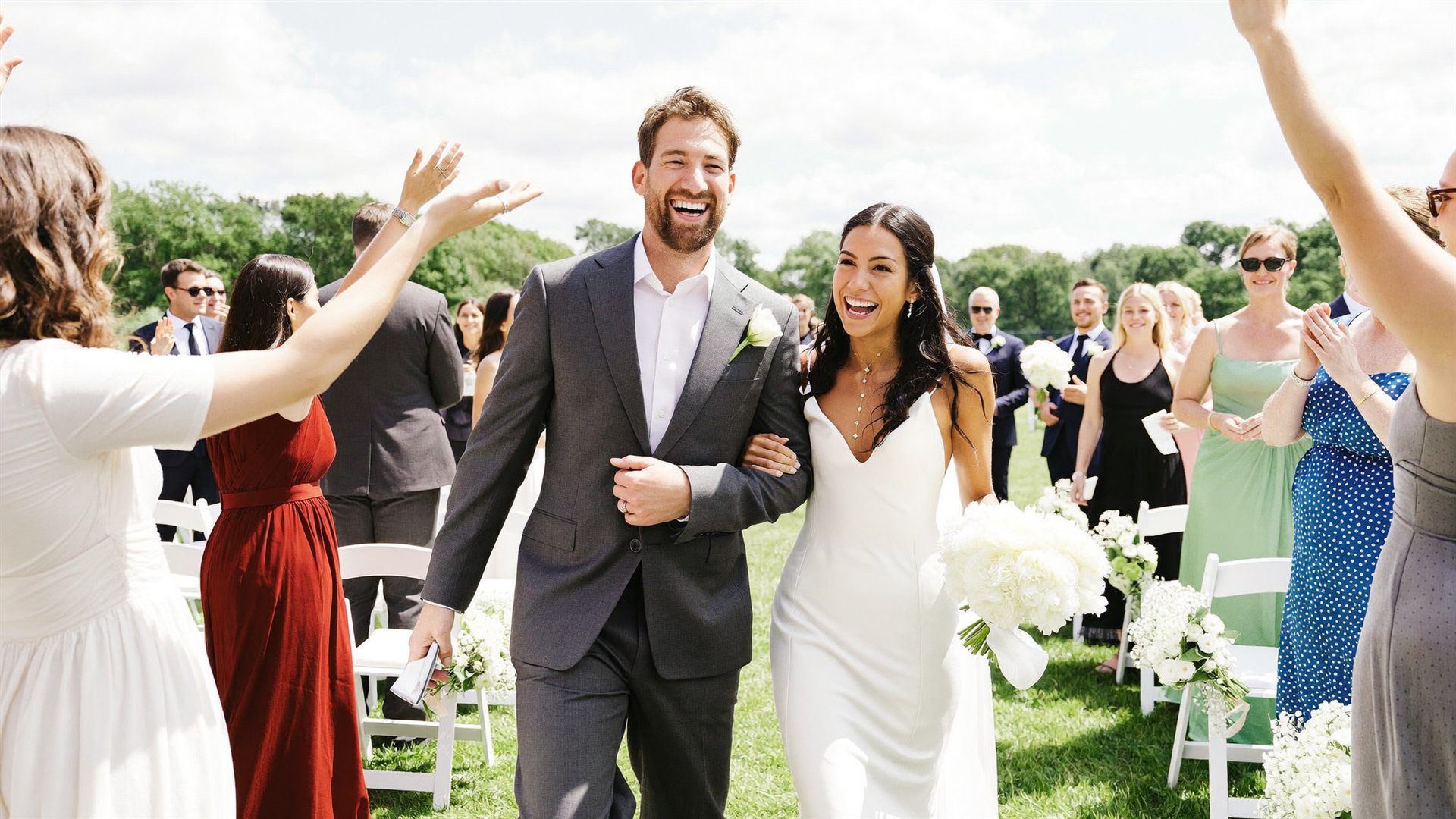 A couple celebrating at a bright outdoor wedding